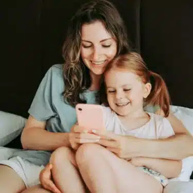 Mutter und Tochter mit Telefon