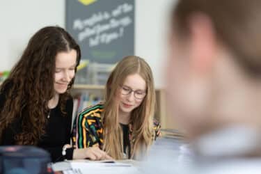 Zwei Schülerinnen lernen gemeinsam im Klassenzimmer