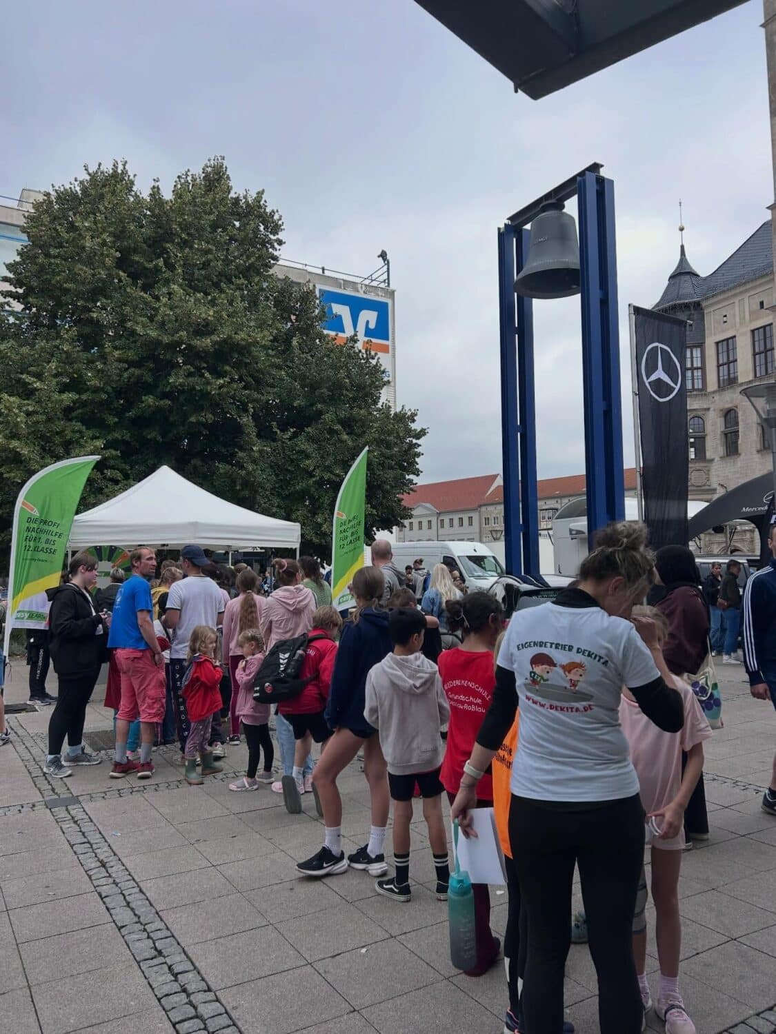 Menschenmenge vor großer Glocke bei Veranstaltung