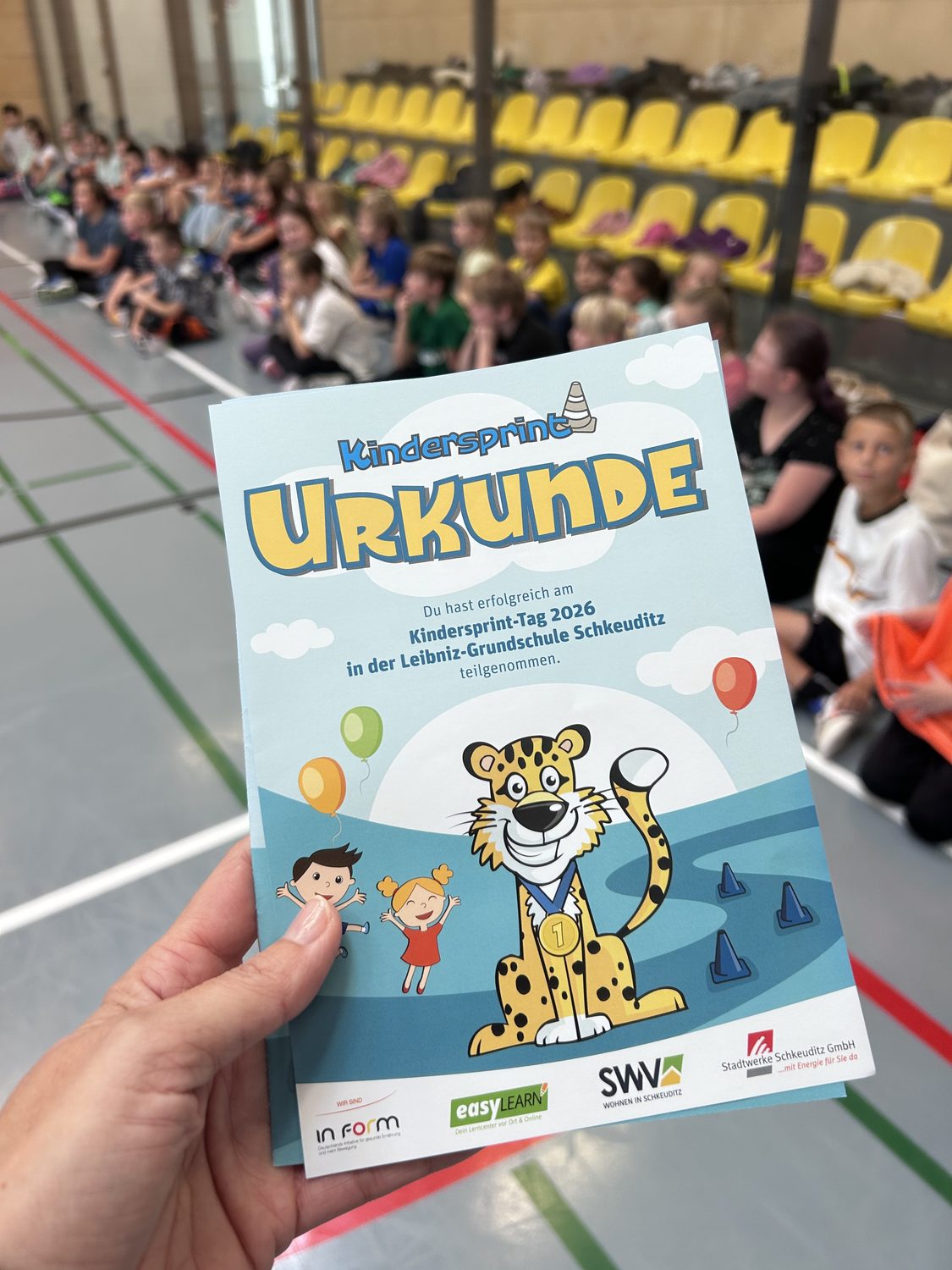 Urkunde beim Kindersprint in einer Sporthalle