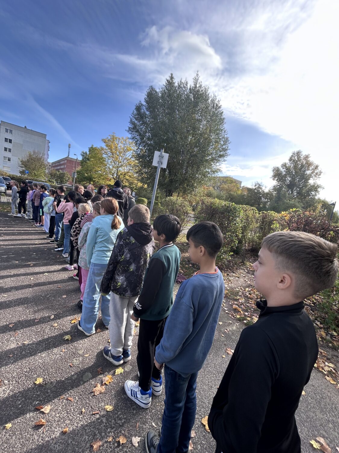 Kinder stehen drau&szlig;en in einer langen Reihe.