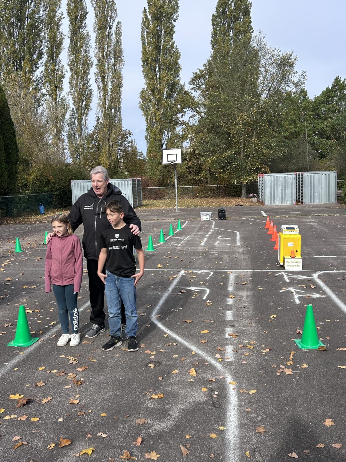 Mann mit zwei Kindern auf Verkehrsparcours im Freien