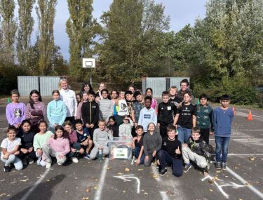 Schulklasse mit Lehrkräften auf Basketballplatz im Herbst