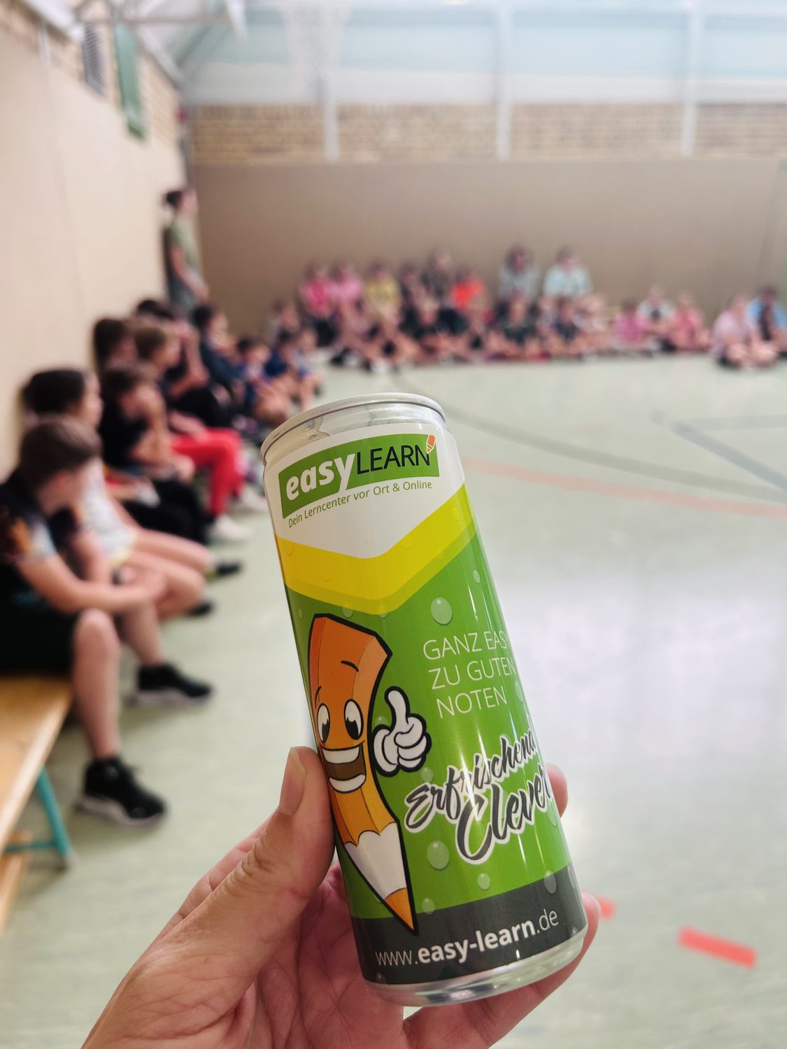 EasyLearn-Getr&auml;nkedose vor sitzenden Kindern in Sporthalle